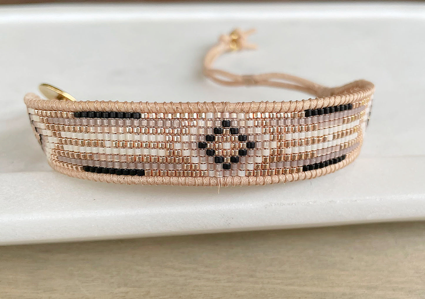 Gold, Beige, and Black Starburst Bead Loom Woven bracelet trimmed with leather