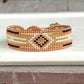 Gold, Honey Tan, and Black Starburst Bead Loom Woven bracelet trimmed with leather